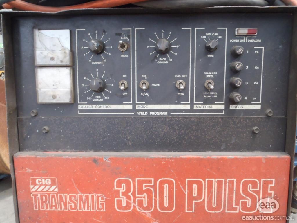 Front panel of a CIG Transmig 350 Pulse showing WIRE, MATERIAL and MODE selector switches with CURRENT and FINE VOLTAGE knobs